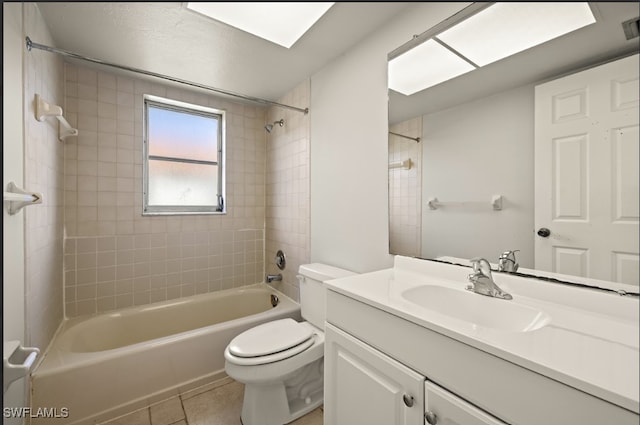 full bathroom with tiled shower / bath combo, vanity, tile patterned floors, and toilet