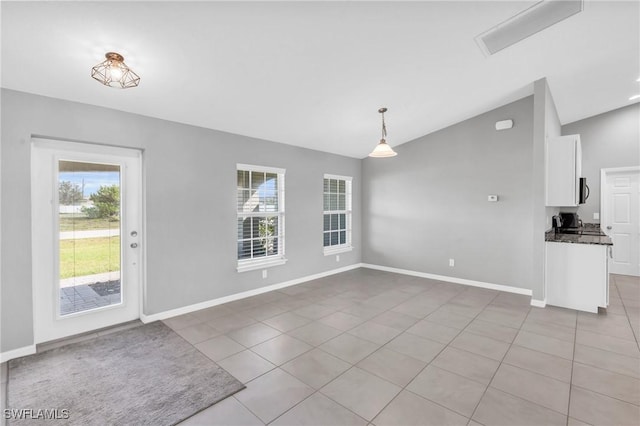 unfurnished dining area with lofted ceiling and light tile patterned floors