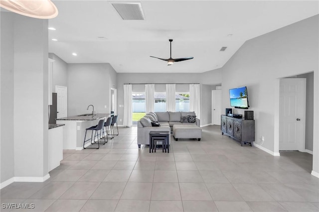 living room featuring sink, high vaulted ceiling, ceiling fan, and light tile patterned flooring