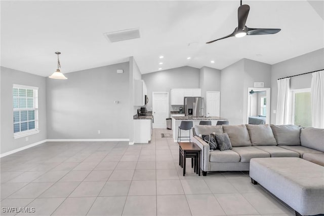 tiled living room featuring ceiling fan and vaulted ceiling