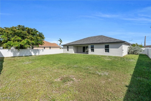 rear view of house featuring a yard