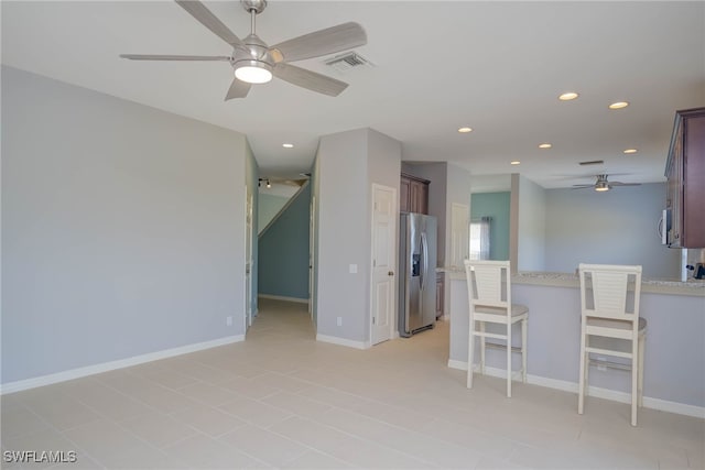 interior space with light stone countertops and ceiling fan