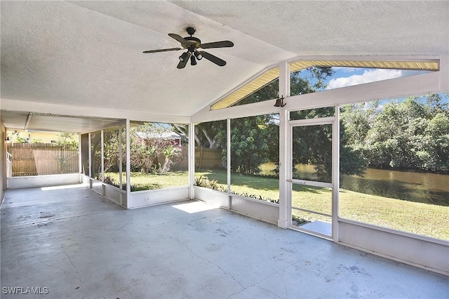 unfurnished sunroom featuring vaulted ceiling, a water view, and ceiling fan