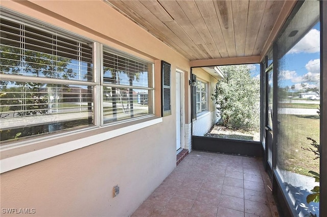 unfurnished sunroom with wood ceiling