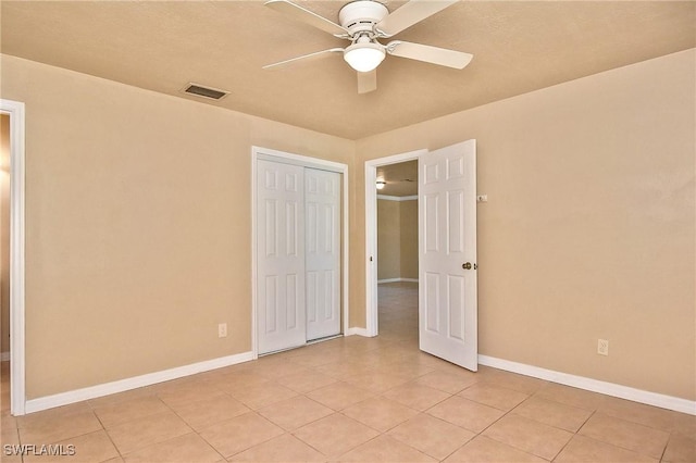 unfurnished bedroom featuring a closet, ceiling fan, and light tile patterned floors