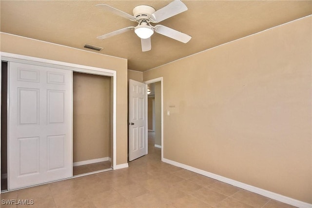 unfurnished bedroom with ceiling fan and a closet