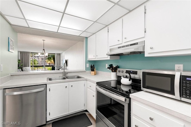 kitchen with stainless steel appliances, white cabinetry, and sink