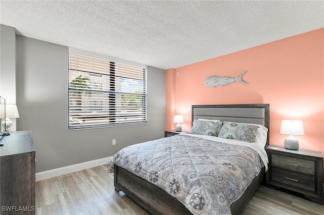 bedroom with light hardwood / wood-style flooring and a textured ceiling