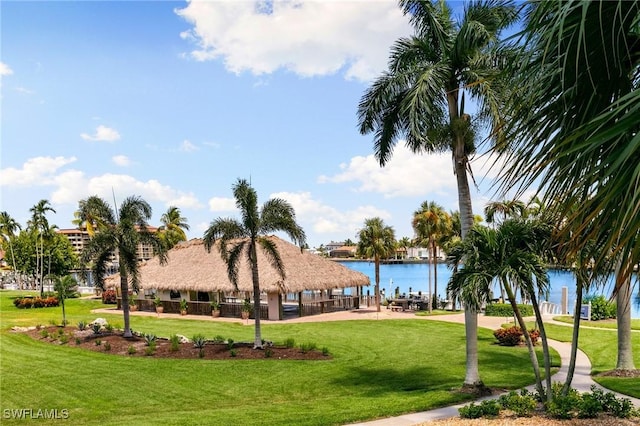 view of property's community with a gazebo, a water view, and a lawn