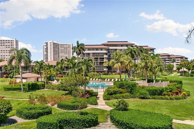 view of community featuring a swimming pool and a lawn