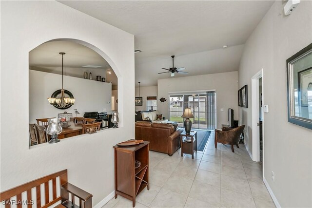 tiled living room featuring lofted ceiling and ceiling fan with notable chandelier