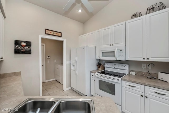 kitchen with white appliances, white cabinets, washer and clothes dryer, and light tile patterned floors