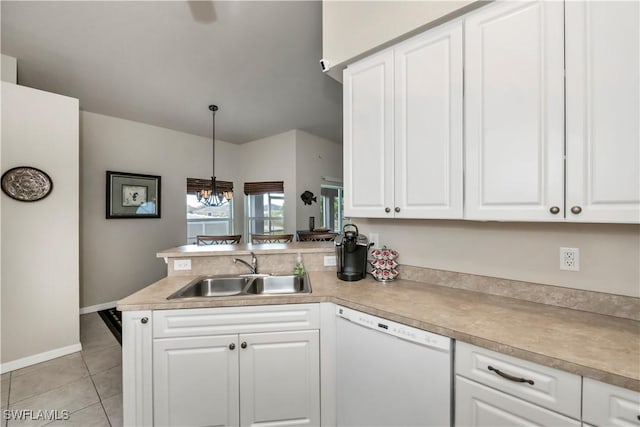 kitchen with light tile patterned floors, a peninsula, white dishwasher, white cabinetry, and a sink