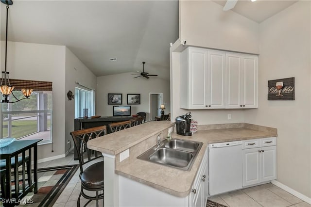 kitchen featuring white dishwasher, light countertops, and a sink