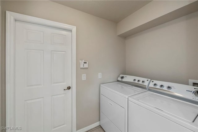 washroom with laundry area, washer and clothes dryer, and baseboards