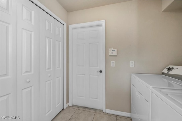 clothes washing area with light tile patterned floors and washing machine and clothes dryer