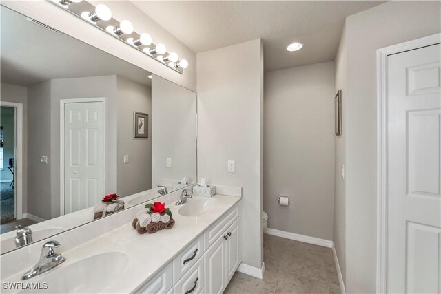 bathroom featuring vanity, tile patterned floors, and toilet