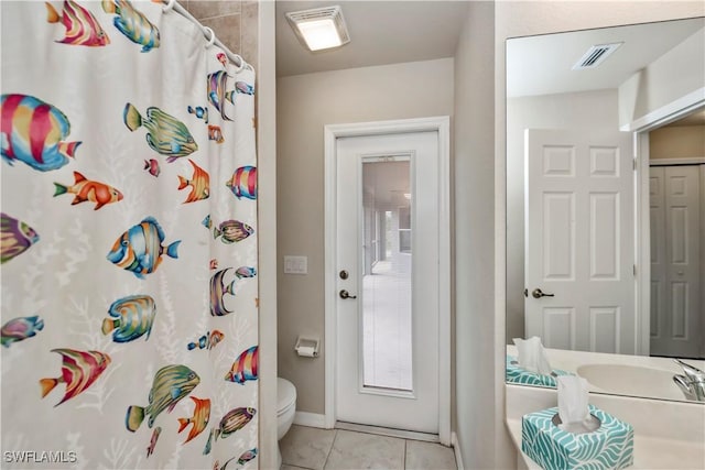 bathroom with a shower with curtain, tile patterned floors, and toilet