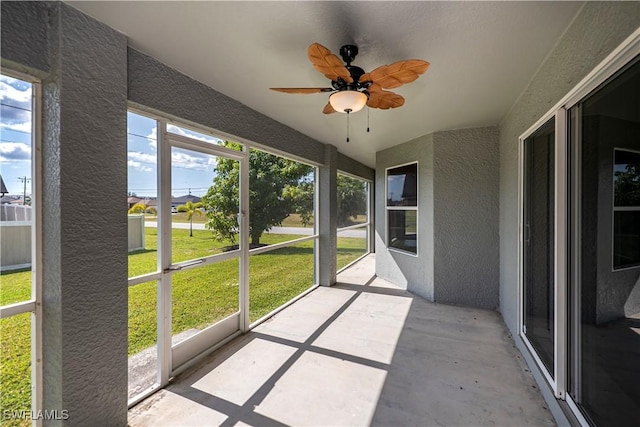 unfurnished sunroom featuring ceiling fan