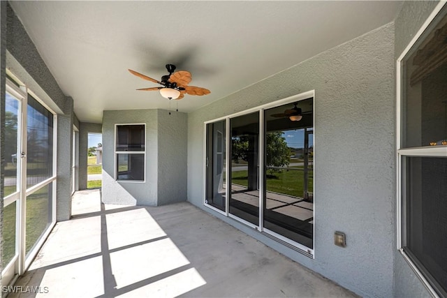 unfurnished sunroom with a ceiling fan