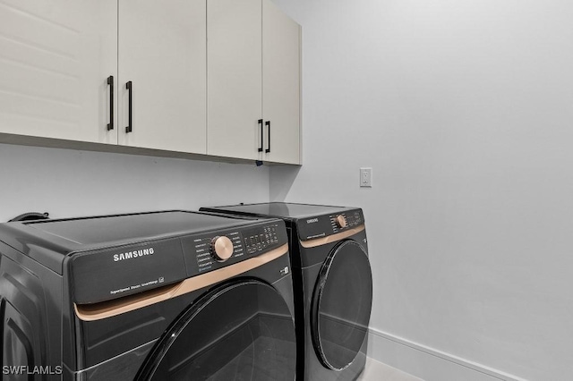 laundry area with cabinets and washing machine and dryer