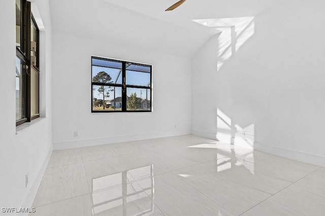 tiled empty room featuring lofted ceiling and ceiling fan