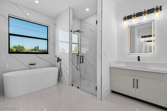 bathroom with vanity and shower with separate bathtub