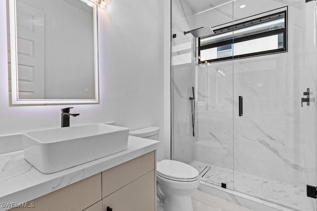 bathroom featuring vanity, toilet, and an enclosed shower