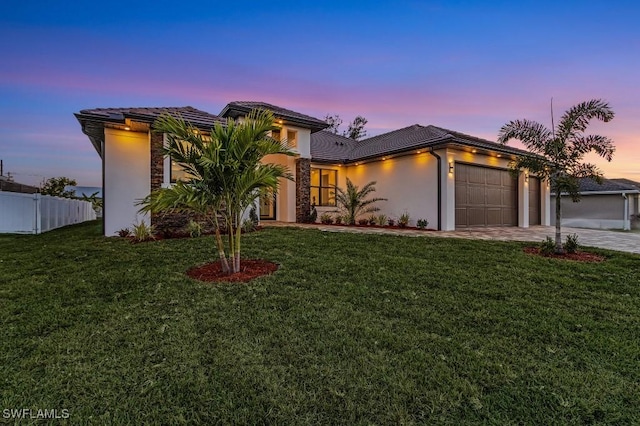 view of front of home with a garage and a yard