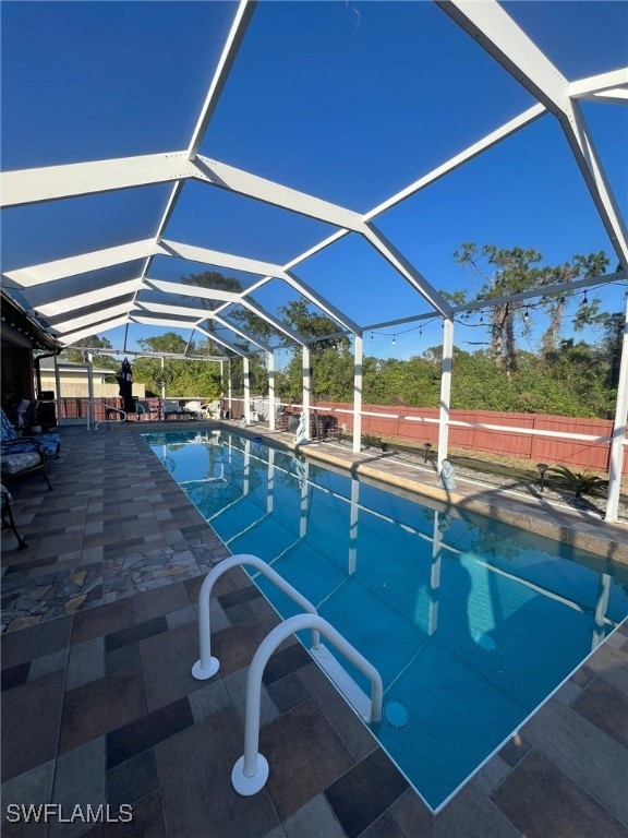 view of swimming pool with a patio and glass enclosure