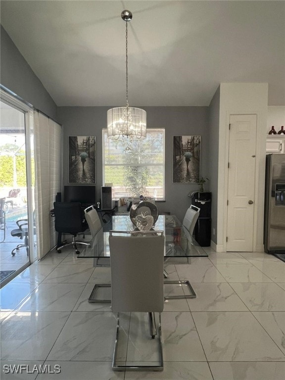 dining area with lofted ceiling and a notable chandelier