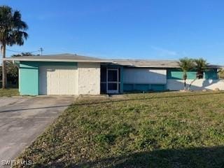 single story home with a garage and a front lawn