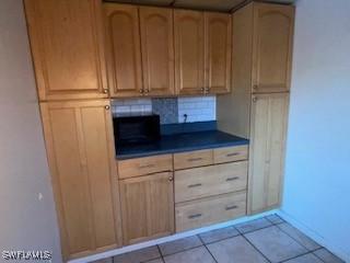 kitchen featuring light tile patterned flooring and decorative backsplash