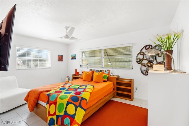 tiled bedroom featuring ceiling fan and a textured ceiling