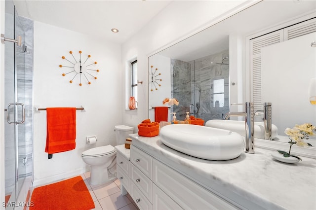 bathroom with toilet, vanity, a shower with door, and tile patterned flooring