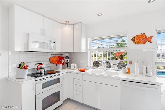 kitchen with sink, white cabinets, white appliances, and decorative backsplash