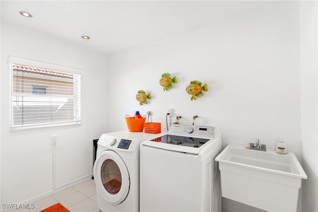 laundry area with light tile patterned flooring, sink, and washer and dryer