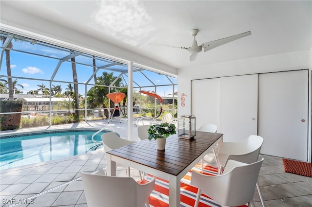 view of swimming pool with a patio, ceiling fan, and glass enclosure