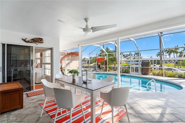 view of swimming pool featuring a patio, ceiling fan, and glass enclosure