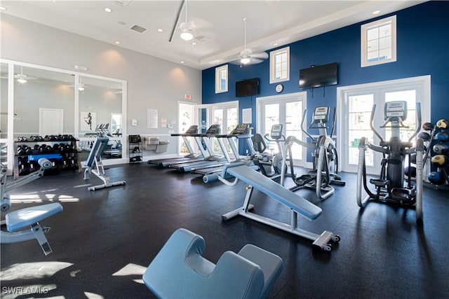 exercise room with french doors, ceiling fan, and a high ceiling