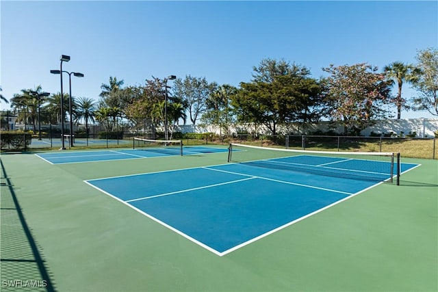 view of tennis court with a mountain view and basketball hoop