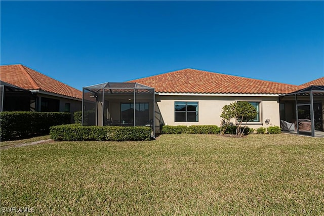 back of house with a yard and a lanai