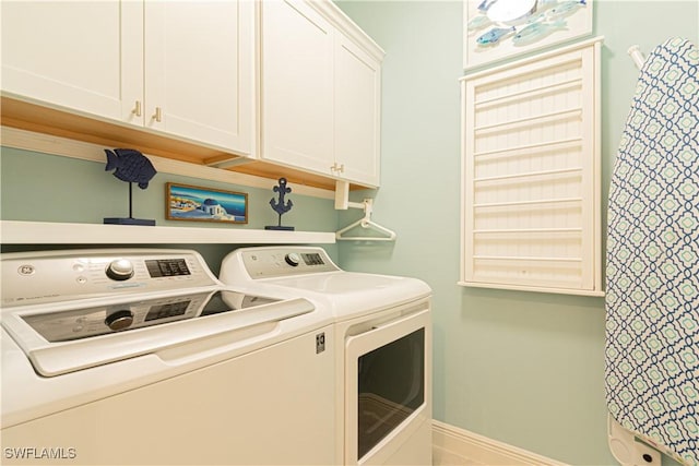 clothes washing area featuring cabinets and independent washer and dryer