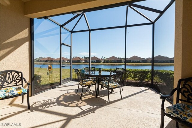 sunroom featuring a water view