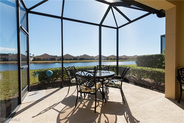 view of patio featuring a water view and glass enclosure