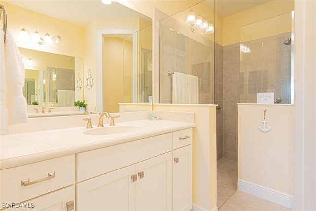 bathroom featuring tile patterned flooring, vanity, and a tile shower