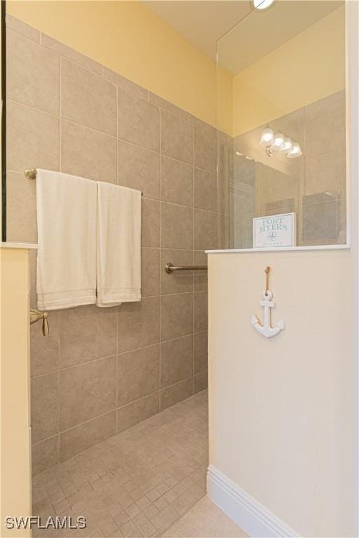 bathroom with tile patterned flooring and a tile shower