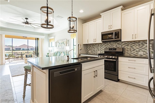 kitchen with a kitchen island with sink, appliances with stainless steel finishes, sink, and white cabinets