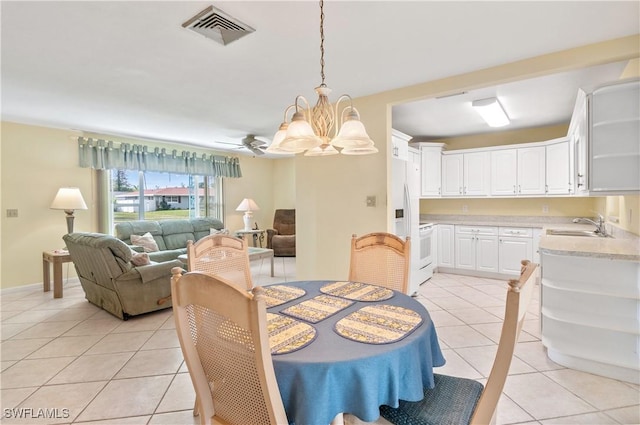 tiled dining room with ceiling fan with notable chandelier and sink