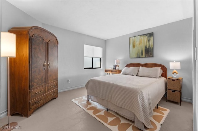 bedroom with baseboards and light colored carpet